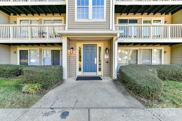 view of exterior entry with a balcony