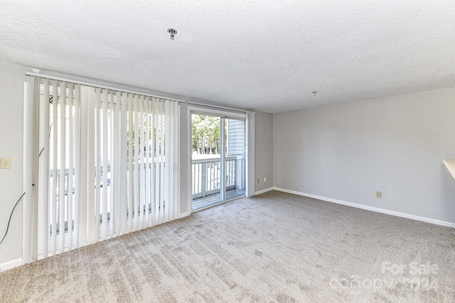 carpeted spare room with a textured ceiling