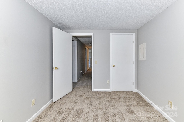 unfurnished bedroom featuring a textured ceiling and light colored carpet