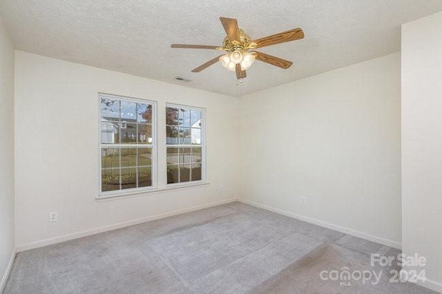 carpeted empty room featuring a textured ceiling and ceiling fan