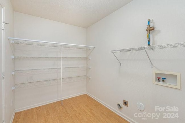 laundry area with gas dryer hookup, hookup for a washing machine, wood-type flooring, and hookup for an electric dryer