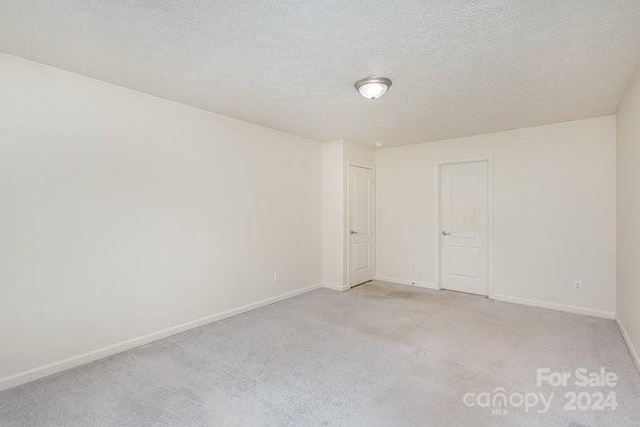 carpeted empty room with a textured ceiling