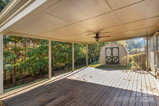 wooden deck with a storage shed and ceiling fan