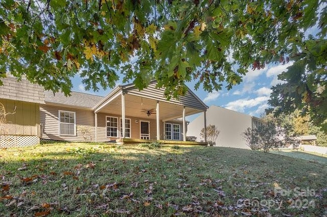 view of front of property with ceiling fan and a front yard