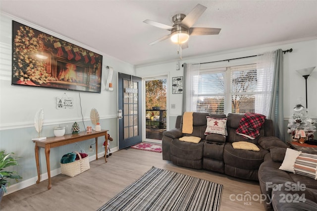 living room with light wood-type flooring, ceiling fan, and crown molding