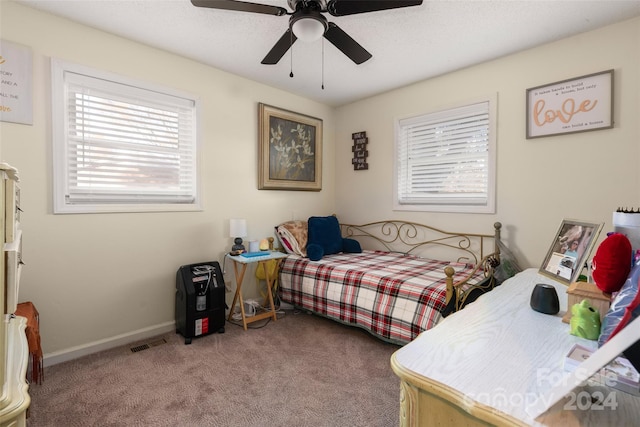 bedroom with multiple windows, ceiling fan, and carpet floors