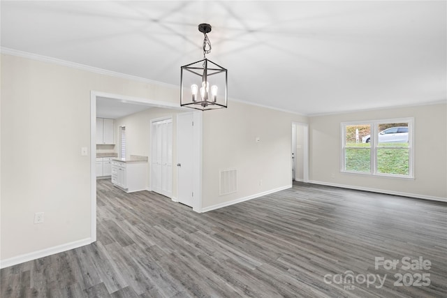 unfurnished dining area featuring ornamental molding, hardwood / wood-style flooring, and a notable chandelier