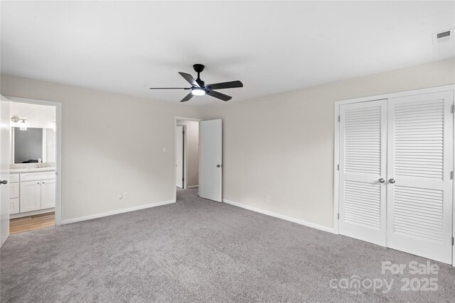 unfurnished bedroom with sink, ceiling fan, connected bathroom, light colored carpet, and a closet