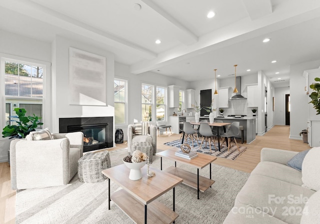 living room with beamed ceiling and light hardwood / wood-style floors