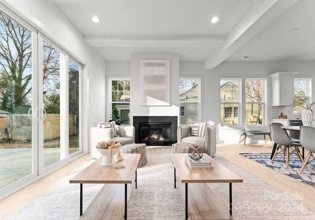 sunroom / solarium featuring beamed ceiling and a multi sided fireplace