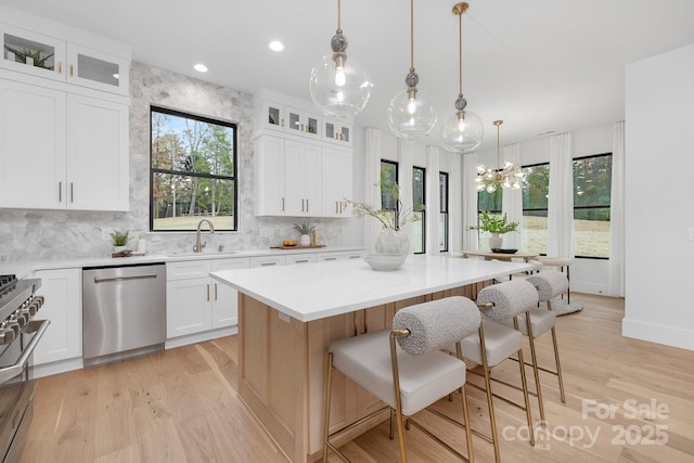 kitchen with a center island, white cabinetry, sink, and appliances with stainless steel finishes