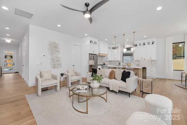 living room featuring ceiling fan and light hardwood / wood-style floors