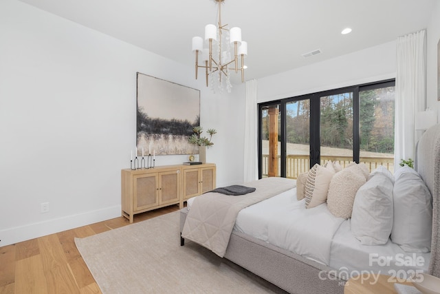 bedroom featuring an inviting chandelier, light wood-type flooring, access to outside, and french doors