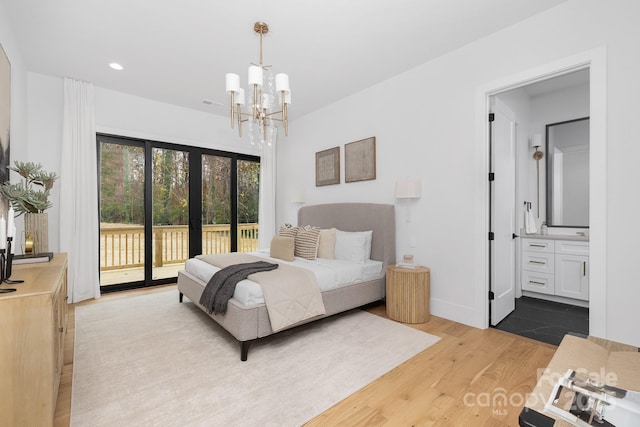 bedroom with access to exterior, a chandelier, light hardwood / wood-style flooring, and ensuite bath