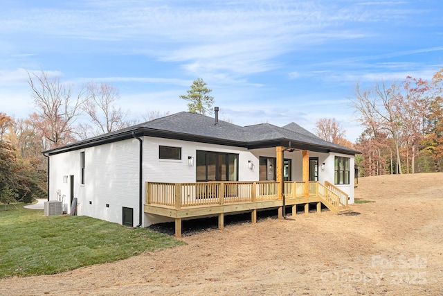 back of property with a lawn, a wooden deck, and central AC