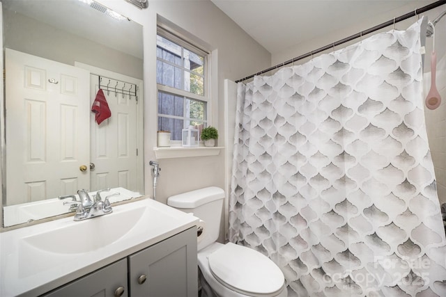 bathroom featuring vanity, toilet, and walk in shower