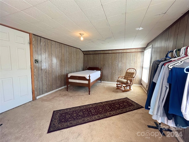 carpeted bedroom with wooden walls and crown molding