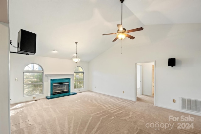 unfurnished living room with ceiling fan, light carpet, and high vaulted ceiling