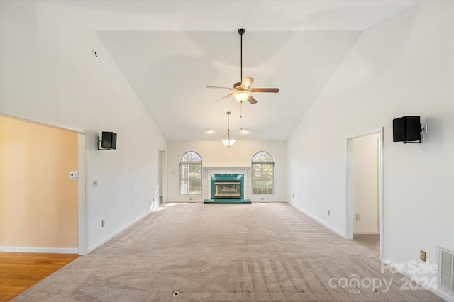 unfurnished living room with ceiling fan, light carpet, and high vaulted ceiling