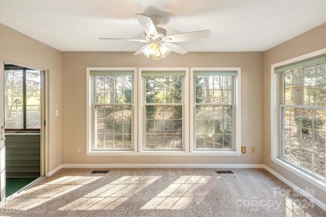 unfurnished sunroom with a wealth of natural light and ceiling fan