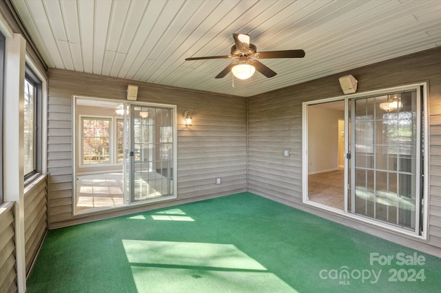 unfurnished sunroom featuring ceiling fan