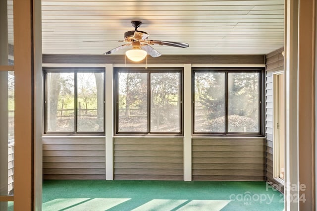 unfurnished sunroom with ceiling fan