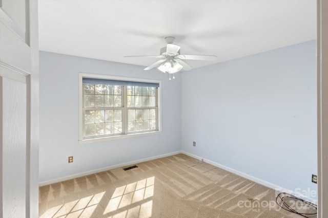 unfurnished room with light colored carpet and ceiling fan