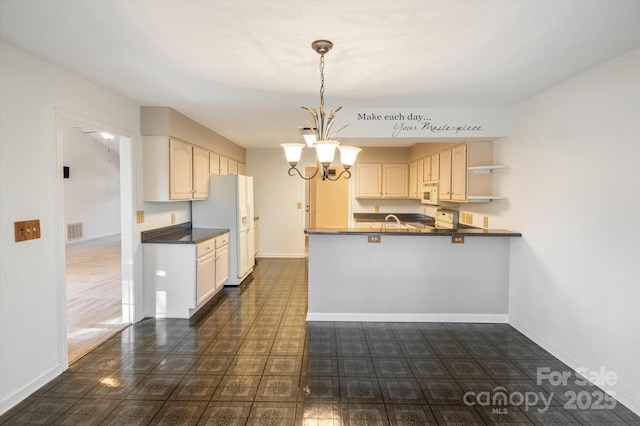 kitchen with a peninsula, white appliances, visible vents, dark countertops, and an inviting chandelier