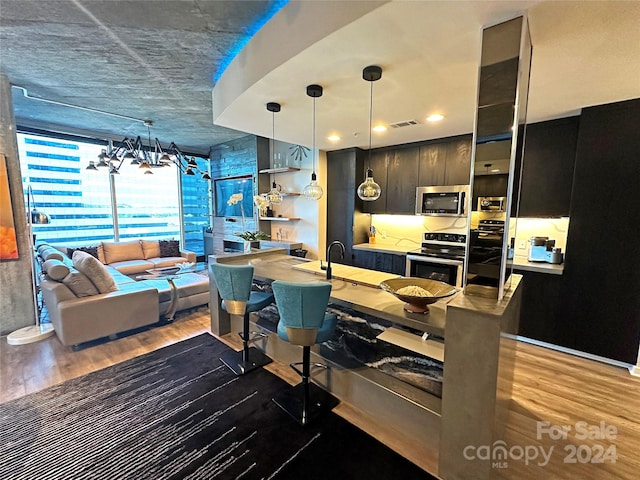 kitchen featuring sink, decorative light fixtures, dark hardwood / wood-style floors, and appliances with stainless steel finishes