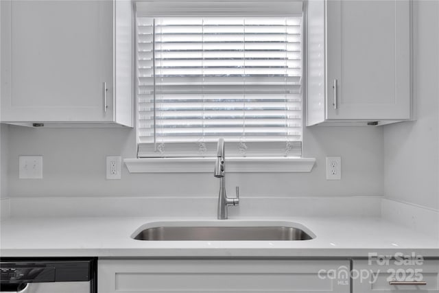 kitchen featuring stainless steel dishwasher, sink, and white cabinets