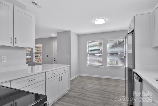 kitchen featuring appliances with stainless steel finishes, white cabinets, and light hardwood / wood-style floors