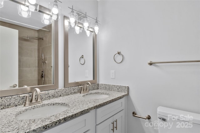 bathroom with vanity, toilet, and a tile shower