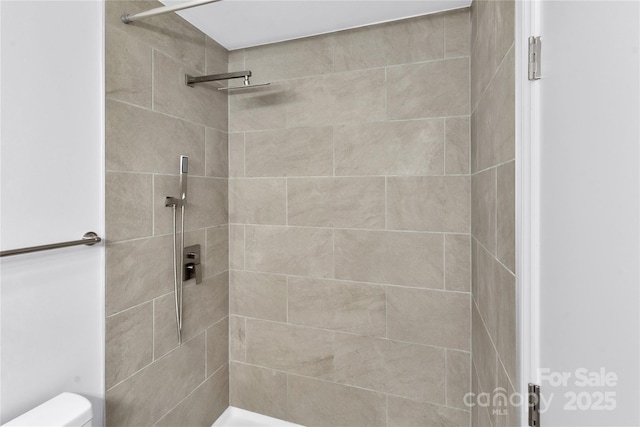 bathroom with tiled shower and toilet