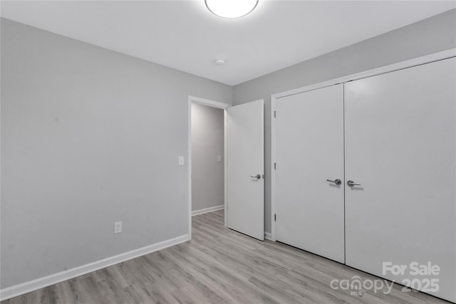 unfurnished bedroom featuring a closet and light wood-type flooring