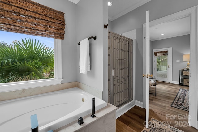 bathroom featuring separate shower and tub, hardwood / wood-style floors, and ornamental molding