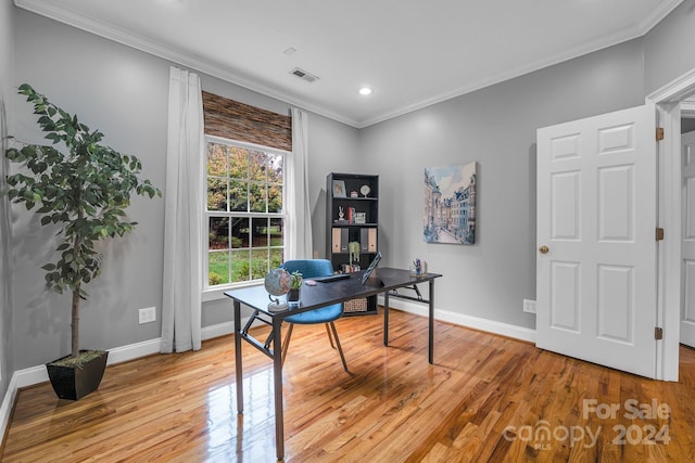 office area with light wood-type flooring and ornamental molding