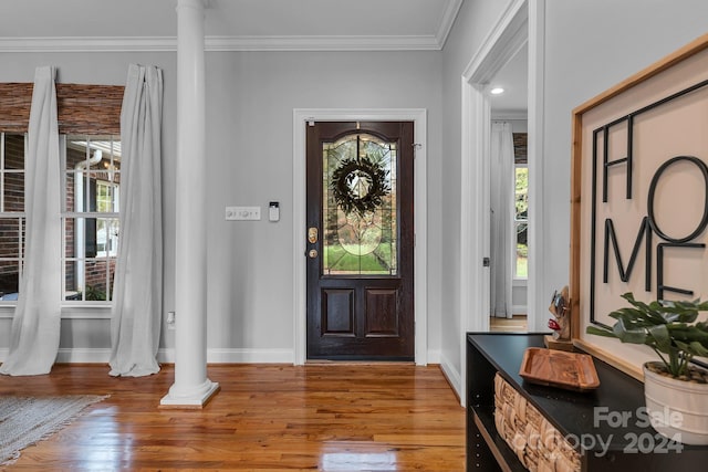 foyer featuring decorative columns, plenty of natural light, and hardwood / wood-style floors