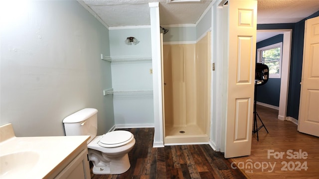 bathroom with hardwood / wood-style flooring, toilet, a shower, vanity, and a textured ceiling