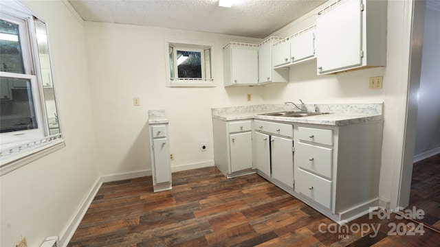 kitchen featuring sink, white cabinetry, a textured ceiling, and dark hardwood / wood-style flooring