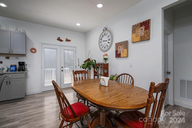 dining room with light hardwood / wood-style floors and french doors