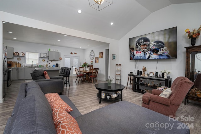 living room with light hardwood / wood-style floors and lofted ceiling