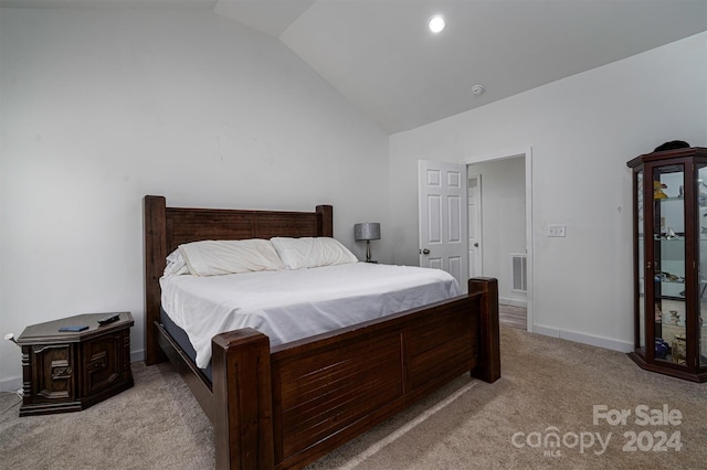 bedroom with lofted ceiling and light colored carpet