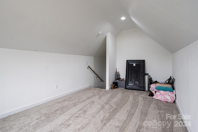 bonus room with carpet flooring and vaulted ceiling