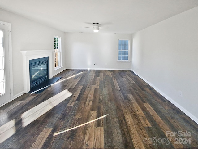 unfurnished living room with ceiling fan and dark hardwood / wood-style flooring