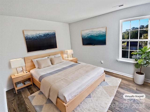 bedroom with dark hardwood / wood-style floors