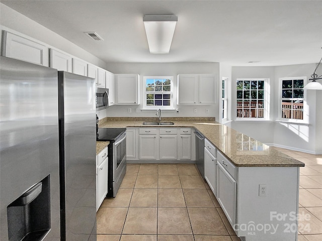 kitchen with appliances with stainless steel finishes, white cabinetry, sink, and pendant lighting