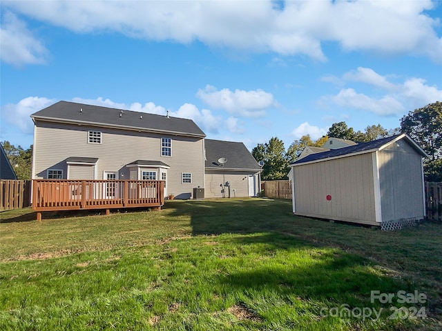 back of property featuring a storage unit, a deck, and a lawn