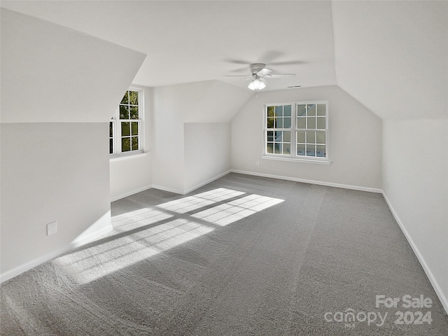 additional living space featuring lofted ceiling, carpet flooring, and ceiling fan