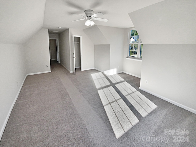 bonus room with lofted ceiling, dark colored carpet, and ceiling fan