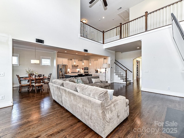 living room featuring ceiling fan, sink, dark hardwood / wood-style floors, and a high ceiling